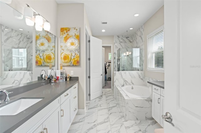 bathroom featuring vanity and independent shower and bath