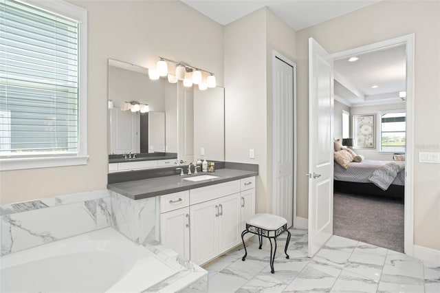 bathroom with vanity and tiled bath