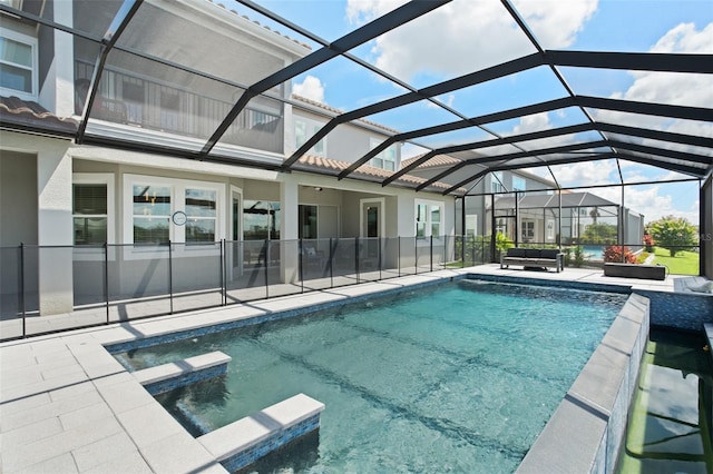 view of swimming pool featuring an in ground hot tub, a patio area, and a lanai