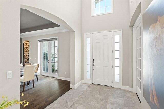 foyer with ornamental molding and french doors