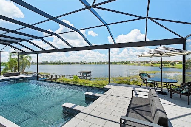 view of pool with glass enclosure, a patio area, and a water view