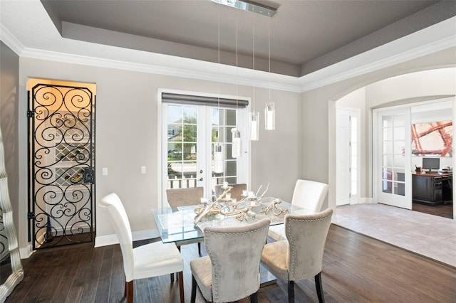 dining area featuring french doors, a tray ceiling, dark hardwood / wood-style floors, and crown molding