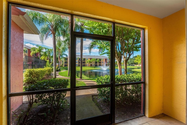 doorway to outside featuring a water view and light tile patterned flooring