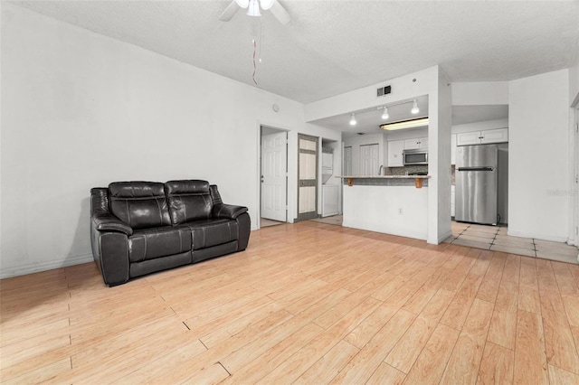 living room with light hardwood / wood-style floors and a textured ceiling