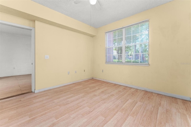 spare room with a textured ceiling, light hardwood / wood-style flooring, and ceiling fan