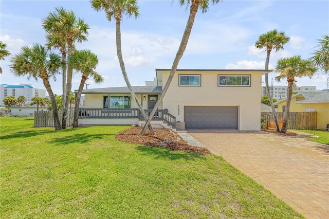 view of front of house featuring a garage and a front lawn