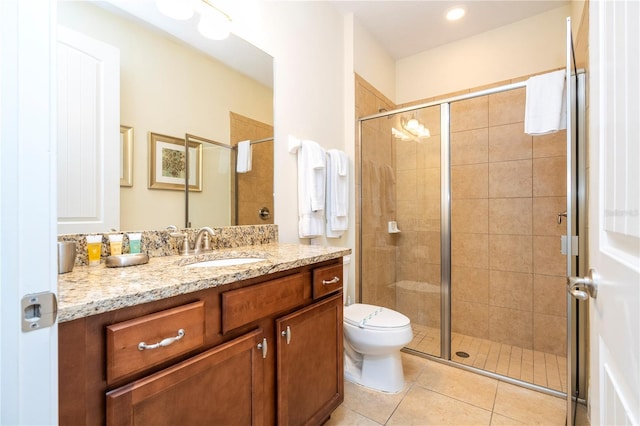 bathroom featuring tile patterned floors, toilet, a shower with shower door, and vanity