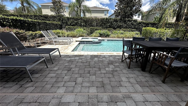 view of pool featuring a patio area and an in ground hot tub