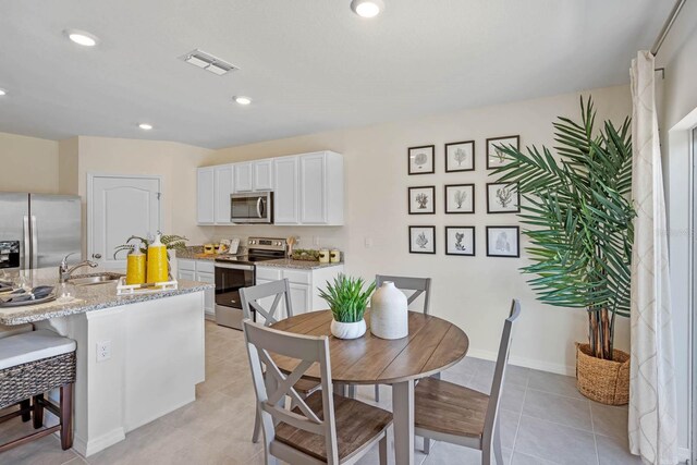 dining area featuring sink and light tile patterned flooring