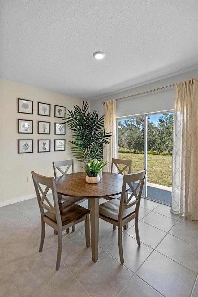 dining room with light tile patterned flooring and a textured ceiling