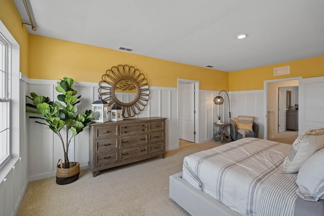 bedroom featuring light carpet and multiple windows