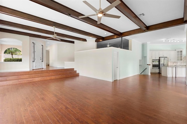 unfurnished living room with ceiling fan, wood-type flooring, and beam ceiling