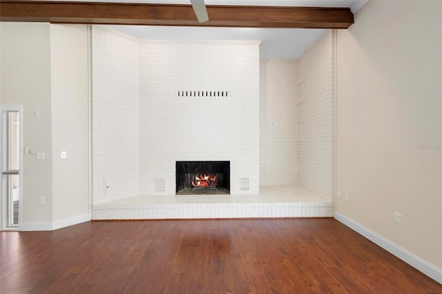 unfurnished living room featuring dark hardwood / wood-style floors, beam ceiling, and a fireplace