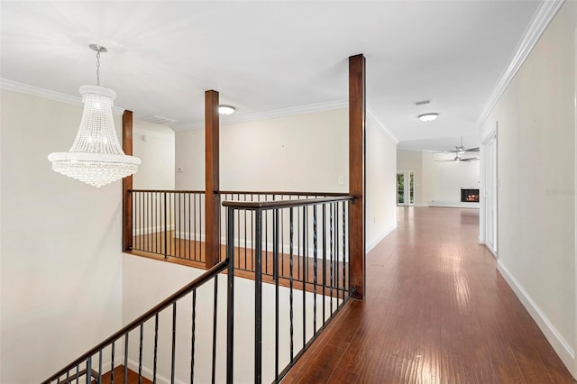 hall with crown molding, a chandelier, and dark hardwood / wood-style flooring