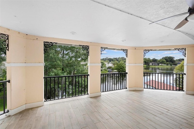 view of patio / terrace with ceiling fan, a balcony, and a water view