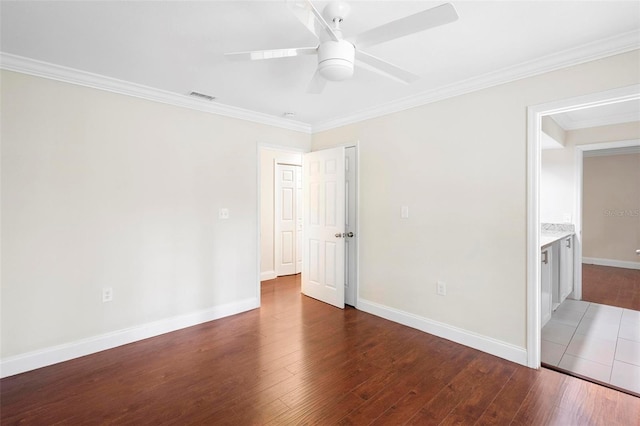 unfurnished room featuring ceiling fan, wood-type flooring, and ornamental molding