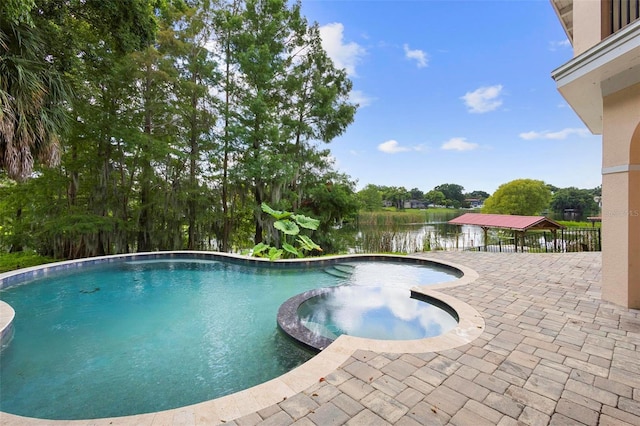 view of swimming pool featuring an in ground hot tub and a water view