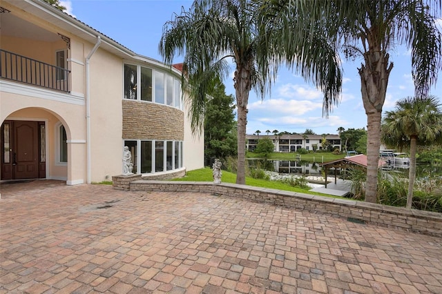 exterior space featuring a balcony and a water view