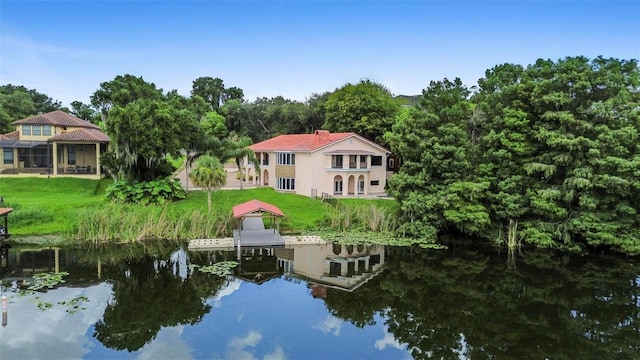 dock area with a lawn and a water view