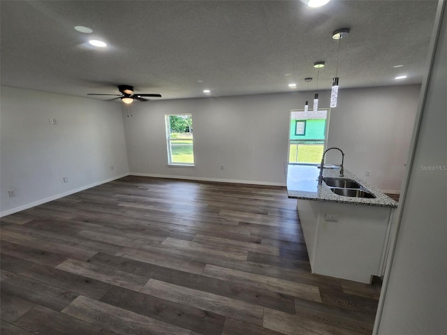 interior space featuring pendant lighting, dark hardwood / wood-style flooring, sink, and ceiling fan