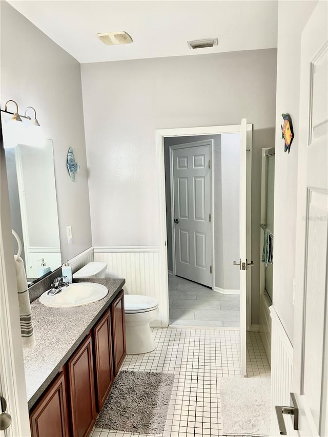 bathroom featuring tile patterned flooring, toilet, and vanity