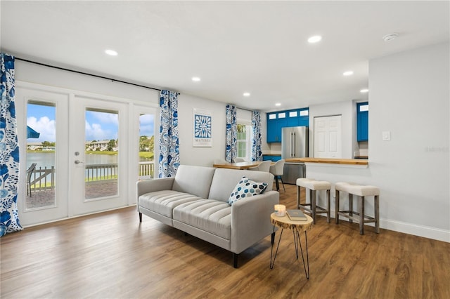 living room with hardwood / wood-style floors and a water view