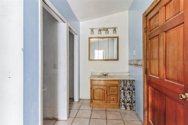 bathroom featuring vanity, tile patterned floors, and lofted ceiling