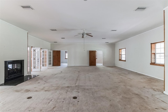 unfurnished living room featuring ornamental molding, light carpet, and a wealth of natural light