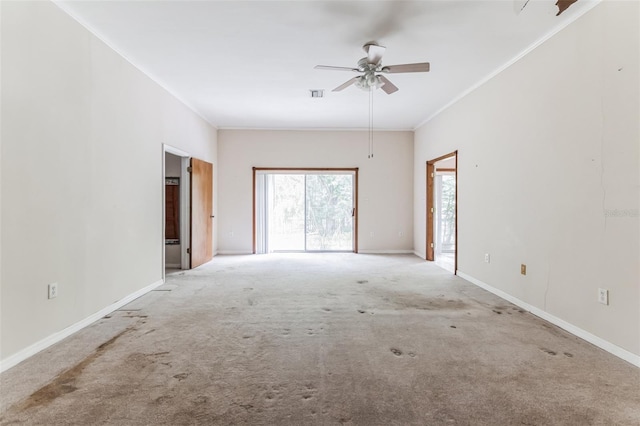 carpeted spare room featuring ceiling fan and ornamental molding