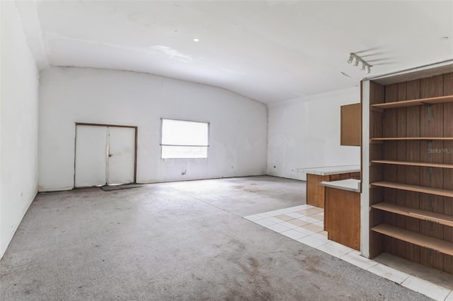 unfurnished living room featuring lofted ceiling and light tile patterned floors