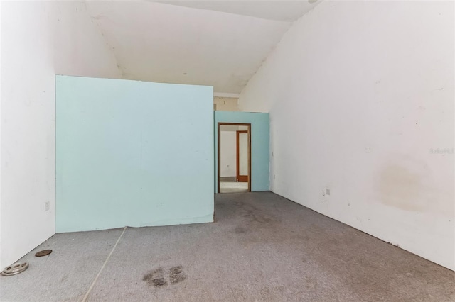 unfurnished room featuring lofted ceiling and carpet floors