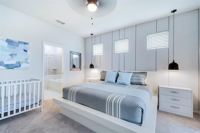 bedroom with light colored carpet and connected bathroom