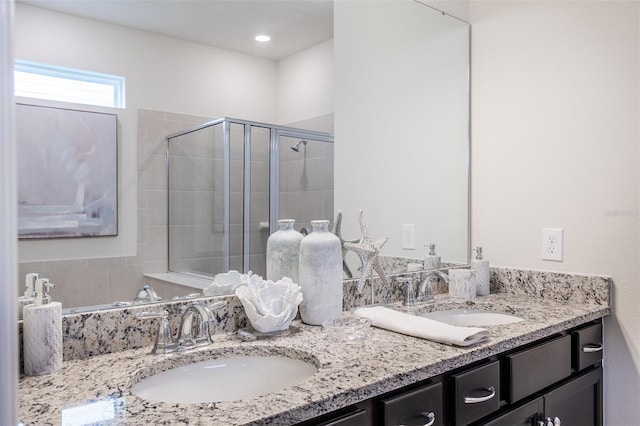 bathroom featuring vanity and a shower with door