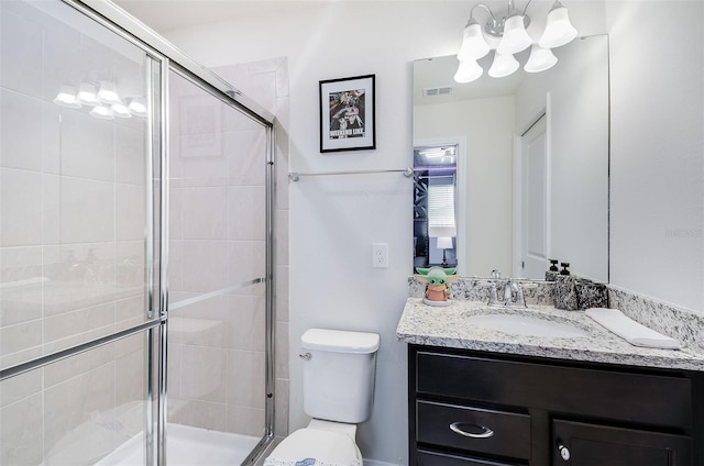 bathroom featuring vanity, toilet, and a shower with door