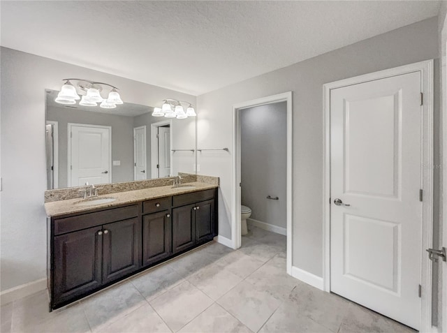 bathroom featuring vanity, a textured ceiling, a chandelier, and toilet