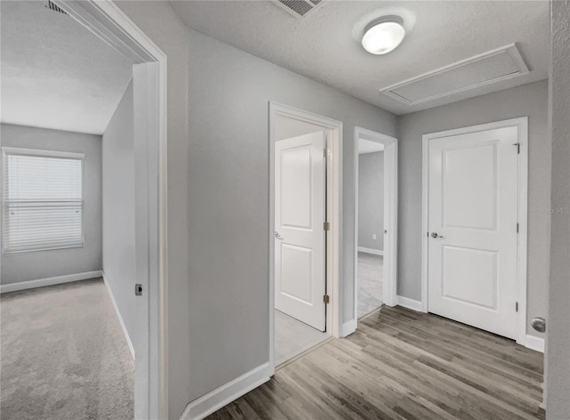 hall with hardwood / wood-style flooring and a textured ceiling