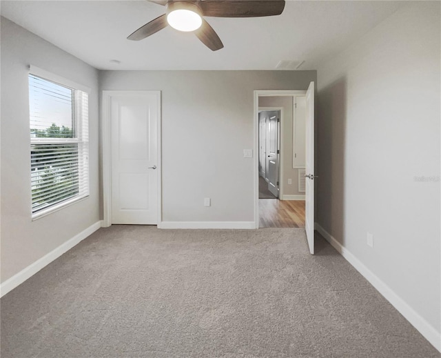 unfurnished room featuring ceiling fan and light carpet