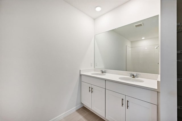 bathroom featuring a tile shower and vanity