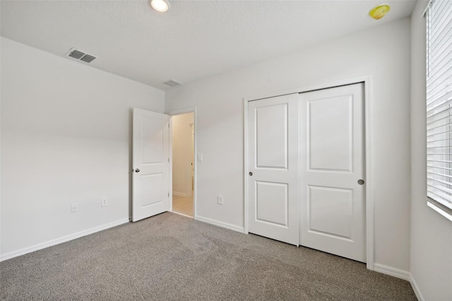 unfurnished bedroom with carpet floors, a closet, and multiple windows