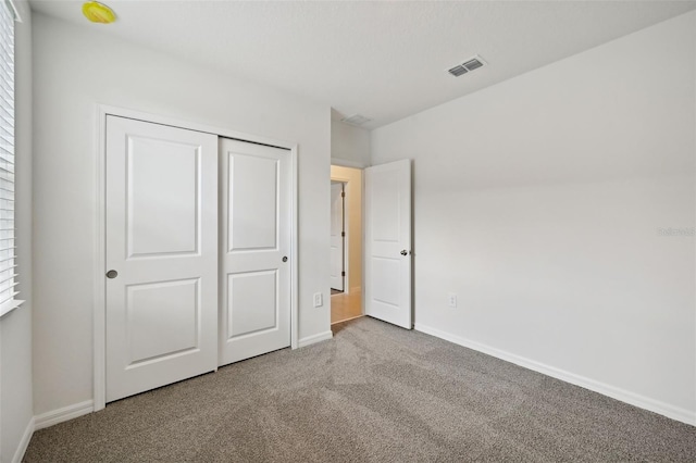 unfurnished bedroom featuring a closet and carpet flooring