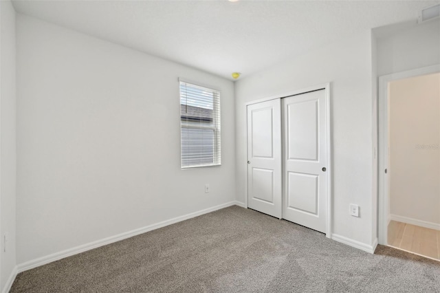 unfurnished bedroom featuring carpet flooring and a closet