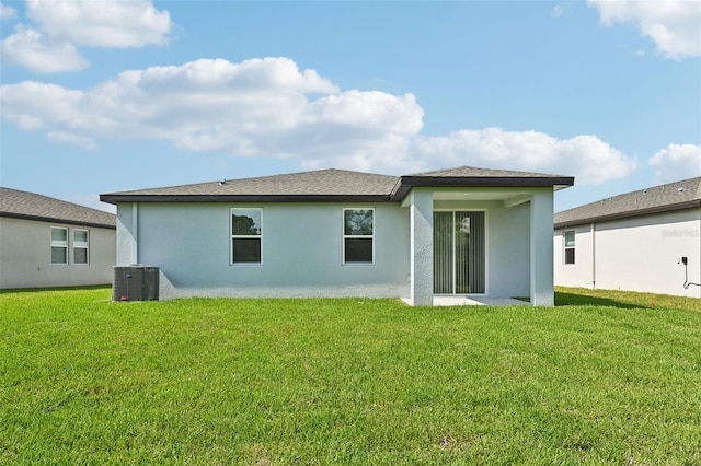 back of house with central AC and a yard