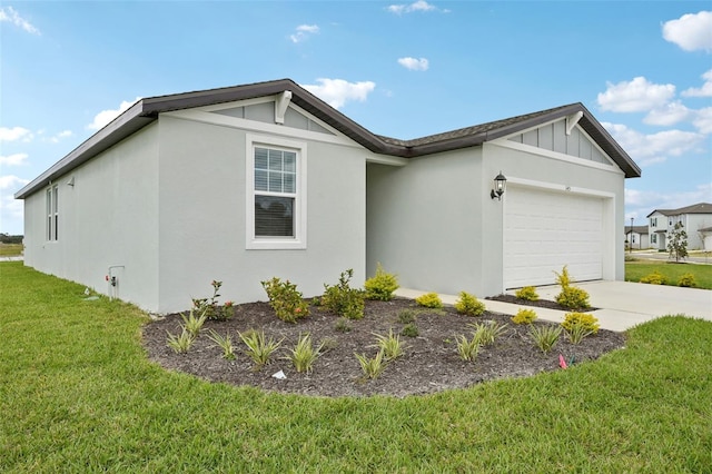 view of side of home featuring a garage, a yard, driveway, stucco siding, and board and batten siding