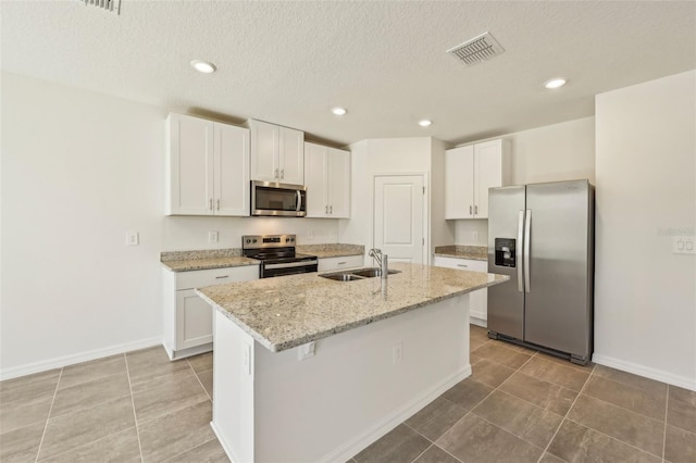 kitchen featuring sink, white cabinets, an island with sink, and appliances with stainless steel finishes