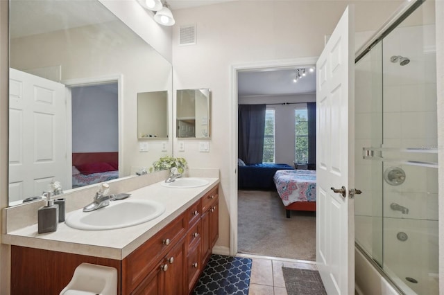 bathroom featuring tile patterned floors, vanity, and enclosed tub / shower combo