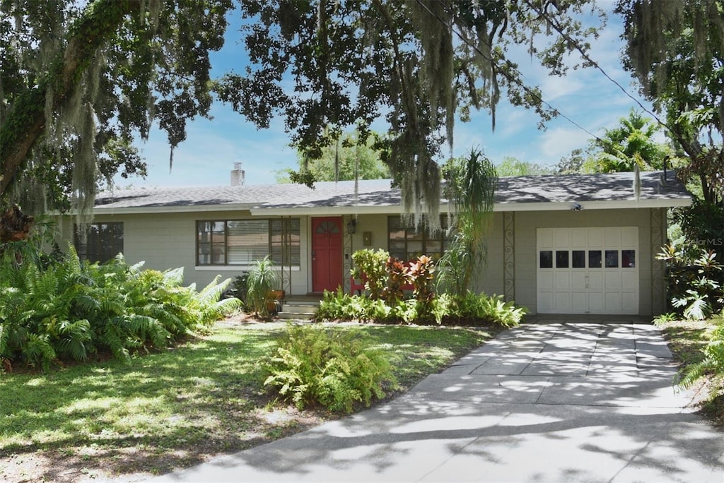 single story home featuring a front lawn and a garage