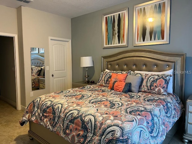 tiled bedroom featuring a textured ceiling