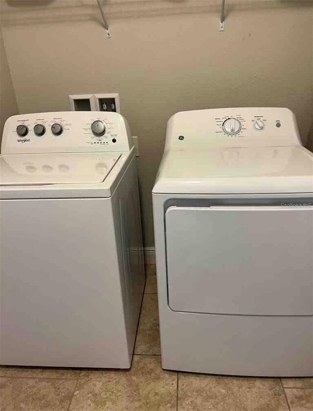 laundry area with light tile patterned floors and independent washer and dryer