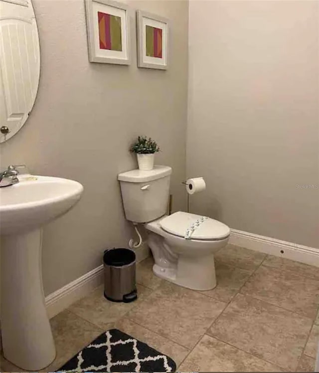 bathroom with sink, tile patterned flooring, and toilet