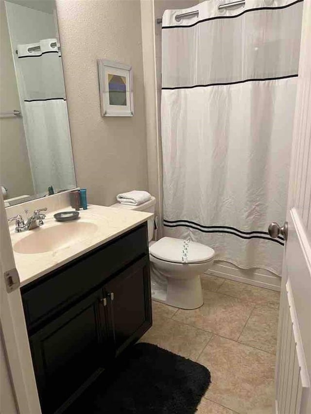 bathroom featuring tile patterned flooring, toilet, and vanity